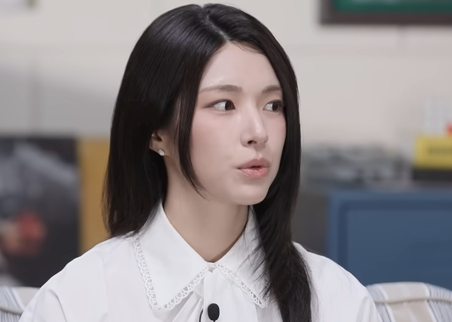 도서관 자료실에서 마이크로필름 리더 화면에 100년 전 신문 지면이 확대되어 떠 있는 장면, 화면 앞 책상에는 낡은 필름 상자와 손글씨 메모지가
